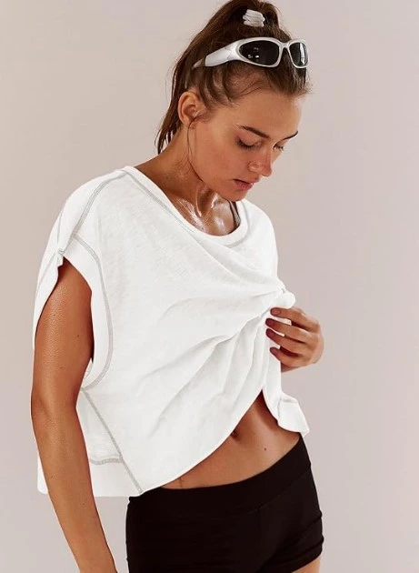 This white cropped athletic tee has an oversized, relaxed fit with a draped open neckline and visible contrast stitching that gives it a cool, elevated edge. It's the kind of top that looks amazing thrown over bike shorts, leggings, or even a midi skirt. The model is styled in full athleisure mode — sporty sunglasses on her head, hair pulled back, effortlessly put together. That energy is exactly what this top delivers. Why you'll love it: Relaxed oversized fit flatters all body types Contrast stitching detail adds a sporty-chic edge Pairs with literally everything in your wardrobe Perfect for workouts, errands, or casual hangouts Shop on Amazon